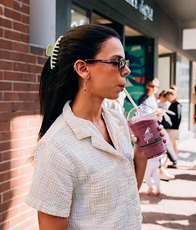 A person drinking an OAKBERRY Smoothie